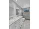 Stylish bathroom showcasing marble counters, double sinks, and a glass shower with contemporary fixtures and patterned floor at 19920 N 69Th Ave, Glendale, AZ 85308