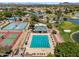 Community pool aerial view showcases swimming lanes, diving blocks, and nearby tennis courts and lawns at 19920 N 69Th Ave, Glendale, AZ 85308