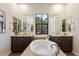 Elegant main bathroom boasts dual vanities, large mirrors, and a soaking tub at 20750 N 87Th St # 1024, Scottsdale, AZ 85255