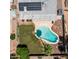 The aerial view showcases a beautiful pool, lush backyard, a grey roof with solar panels, and desert landscape at 2139 W Obispo Ave, Mesa, AZ 85202