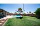 A beautifully landscaped yard with green grass features a refreshing pool and covered patio perfect for outdoor entertaining at 2139 W Obispo Ave, Mesa, AZ 85202