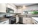 Clean kitchen with stainless steel microwave, oven, dishwasher, and dark granite countertops at 2139 W Obispo Ave, Mesa, AZ 85202