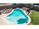 A sparkling swimming pool with steps and pristine turquoise water is surrounded by desert landscaping and mature greenery at 2139 W Obispo Ave, Mesa, AZ 85202