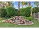 Lush backyard with a rock waterfall feature, artificial turf, and mature trees at 21912 E Desert Hills Dr, Queen Creek, AZ 85142