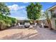 Backyard patio with an outdoor seating area, privacy walls, and lush landscaping at 21912 E Desert Hills Dr, Queen Creek, AZ 85142
