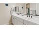 Bathroom with dual vanities, white countertops and decorative mirrors at 21912 E Desert Hills Dr, Queen Creek, AZ 85142
