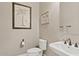 Powder room featuring pedestal sink, toilet and palm tree art at 21912 E Desert Hills Dr, Queen Creek, AZ 85142