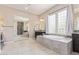 Bathroom with soaking tub with large windows allowing for natural light and a large mirror at 21912 E Desert Hills Dr, Queen Creek, AZ 85142