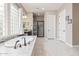 Bright bathroom featuring a soaking tub, glass block window, and a separate walk-in shower at 21912 E Desert Hills Dr, Queen Creek, AZ 85142