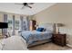 Spacious bedroom with ceiling fan, large windows offering natural light, an upholstered bed and decorative curtains at 21912 E Desert Hills Dr, Queen Creek, AZ 85142