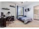 Cozy bedroom with neutral carpet, single bed, tv, and desk near a door to the bath at 21912 E Desert Hills Dr, Queen Creek, AZ 85142
