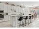 Bright kitchen features a center island with seating, white cabinets and stainless steel appliances at 21912 E Desert Hills Dr, Queen Creek, AZ 85142