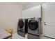 Laundry room featuring modern side-by-side washer and dryer and white cabinets at 21912 E Desert Hills Dr, Queen Creek, AZ 85142