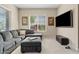 Inviting living room featuring a plush gray sofa, natural light, and a mounted TV at 21912 E Desert Hills Dr, Queen Creek, AZ 85142