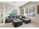 Bright living room with plush gray sofa, large windows, and neutral decor at 21912 E Desert Hills Dr, Queen Creek, AZ 85142