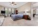 Comfortable primary bedroom features a ceiling fan and ensuite bathroom access at 21912 E Desert Hills Dr, Queen Creek, AZ 85142