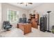 Bright office space with desk, computer, shelves, filing cabinet, and comfortable chair at 21912 E Desert Hills Dr, Queen Creek, AZ 85142