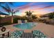 Beautiful backyard pool with a rock waterfall and ample seating at 21912 E Desert Hills Dr, Queen Creek, AZ 85142