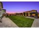 Spacious backyard features lush green grass, a cozy seating area, and a paved patio at 22870 E Sonoqui Blvd, Queen Creek, AZ 85142