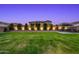 Expansive backyard with a manicured lawn, trees along the perimeter, and a comfortable outdoor seating area at 22870 E Sonoqui Blvd, Queen Creek, AZ 85142