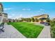 A wide shot of the backyard featuring an expansive lawn, mature landscaping, and stylish patio furniture at 22870 E Sonoqui Blvd, Queen Creek, AZ 85142