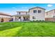 Home's backyard with a large lawn, outdoor kitchen, and entertainment area, ideal for gatherings at 22870 E Sonoqui Blvd, Queen Creek, AZ 85142