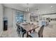 Bright dining area with a wooden table, modern lighting, and access to the kitchen and living room at 22870 E Sonoqui Blvd, Queen Creek, AZ 85142