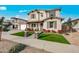 Two-story home featuring manicured lawn, stone pillars, and a welcoming front porch with wood supports at 22870 E Sonoqui Blvd, Queen Creek, AZ 85142