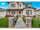 Charming two-story home with a well-manicured lawn and inviting front porch and stone pillar detail at 22870 E Sonoqui Blvd, Queen Creek, AZ 85142