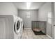 Well-equipped laundry room with tile floors, laundry machines, and pet kennel at 22870 E Sonoqui Blvd, Queen Creek, AZ 85142