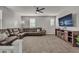 Cozy living room with plush carpeting, comfortable leather sectional, and modern media center at 22870 E Sonoqui Blvd, Queen Creek, AZ 85142