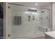Glass enclosed shower featuring a shower bench and modern tile work at 2339 E Questa Dr, Phoenix, AZ 85024