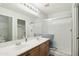 Bathroom featuring dual sinks, framed mirror, updated lighting, and a glass enclosed shower at 2401 E Antigua Dr, Casa Grande, AZ 85194