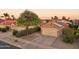 Charming home exterior with solar panels, desert landscaping, and a two-car garage at sunset at 2401 E Antigua Dr, Casa Grande, AZ 85194