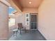 Covered front porch features a chair and small table, offering a cozy outdoor relaxation space at 2401 E Antigua Dr, Casa Grande, AZ 85194