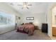 Bright main bedroom featuring neutral walls, carpet, a ceiling fan, and a large window providing ample natural light at 2401 E Antigua Dr, Casa Grande, AZ 85194