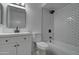 Bright bathroom featuring a modern vanity and shower with sleek, white subway tile and black hardware at 2421 E Dragoon Ave, Mesa, AZ 85204