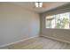 A cozy bedroom featuring new floors and a ceiling fan; bright light shines in through the window at 2421 E Dragoon Ave, Mesa, AZ 85204