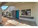 Inviting covered front entrance featuring a blue door and a glimpse of the surrounding landscaping at 2421 E Dragoon Ave, Mesa, AZ 85204