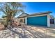 Well-kept house with desert landscaping and a large blue garage door providing ample parking and storage space at 2421 E Dragoon Ave, Mesa, AZ 85204