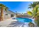 Beautiful pool surrounded by palm trees, landscaping, block wall, and perimeter fence at 2421 E Dragoon Ave, Mesa, AZ 85204