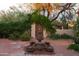 Backyard landscape design with a unique fountain feature and brick pavers at 2430 N 56Th St, Phoenix, AZ 85008