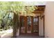 Covered patio with rustic wood beams and wooden framed doors with a view of a courtyard at 2430 N 56Th St, Phoenix, AZ 85008