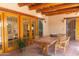 Covered patio with a wooden dining table, wicker chairs, and access to indoor living spaces at 2430 N 56Th St, Phoenix, AZ 85008