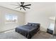 Spacious bedroom with ceiling fan, large window, and gray carpet at 24559 W Flores Dr, Buckeye, AZ 85326