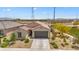 A view of a home's exterior showing desert landscaping and proximity to a sports complex in the background at 24559 W Flores Dr, Buckeye, AZ 85326