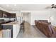 Modern kitchen with granite countertops, dark cabinets, and stainless steel appliances adjacent to living room at 24559 W Flores Dr, Buckeye, AZ 85326
