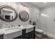 Bright bathroom featuring dual farmhouse sinks, subway tile walls, and a glass-enclosed shower at 2634 E Tamarisk St, Gilbert, AZ 85296