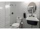 Chic black-and-white bathroom with a sleek sink, toilet, and walk-in shower, complete with modern fixtures at 2634 E Tamarisk St, Gilbert, AZ 85296
