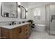 Bright bathroom featuring a dual sink vanity, soaking tub, and walk-in shower with modern fixtures at 2634 E Tamarisk St, Gilbert, AZ 85296